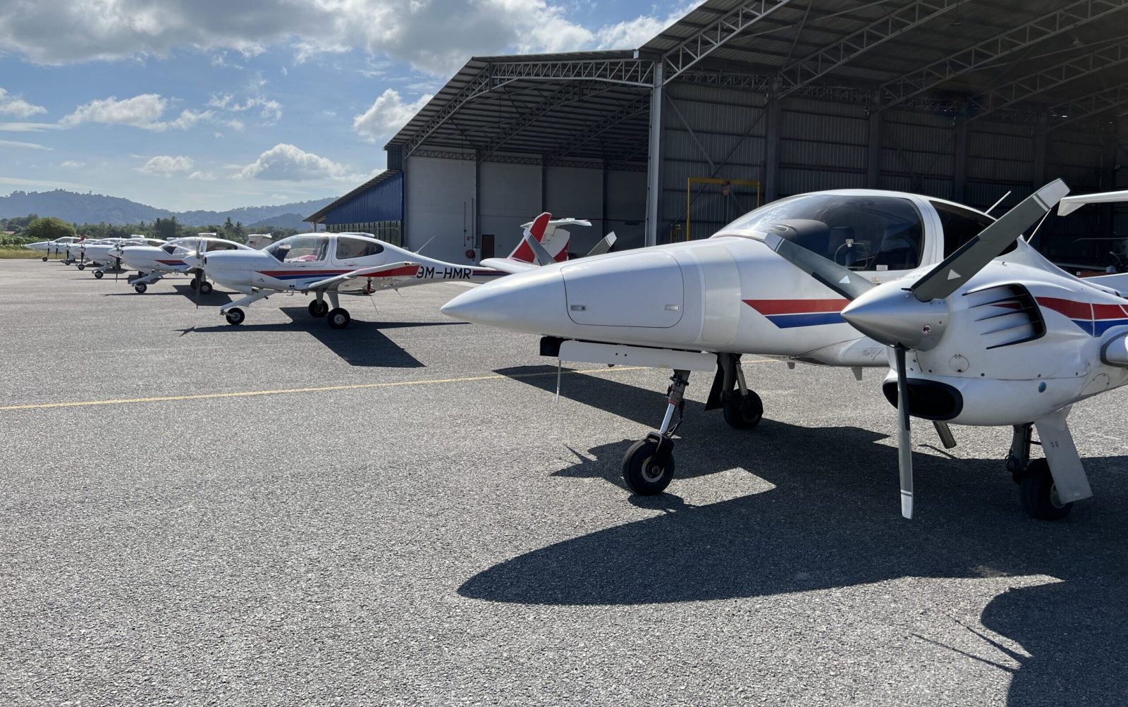 HM Aerospace training aircraft parked beside the aircraft hangar